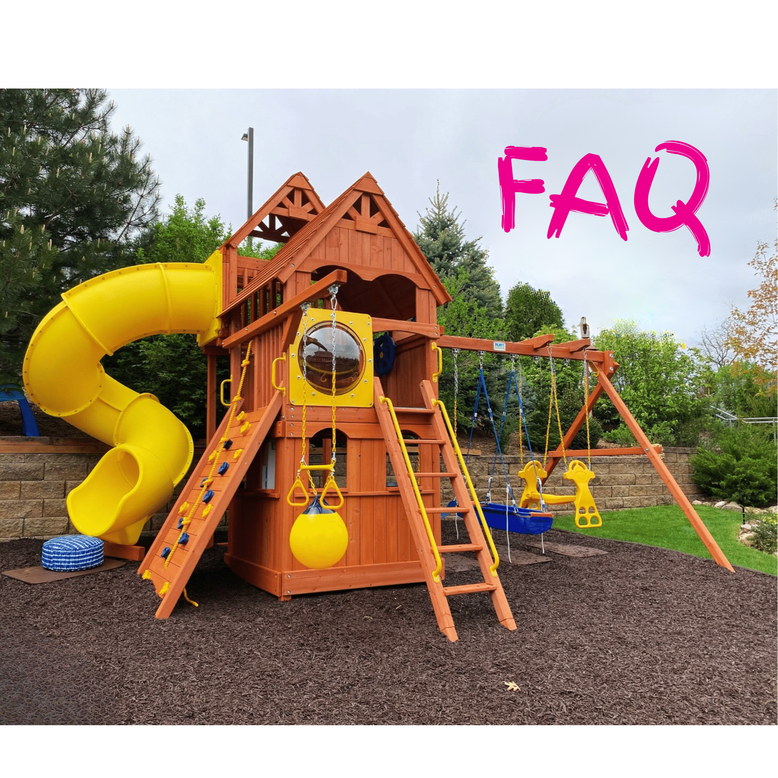A large wooden backyard playset with a yellow spiral slide, climbing ladder, swing set, and small blue bucket swing, shown outdoors on a mulch surface with trees and sky in the background. The word 'FAQ' appears in pink text in the upper right.