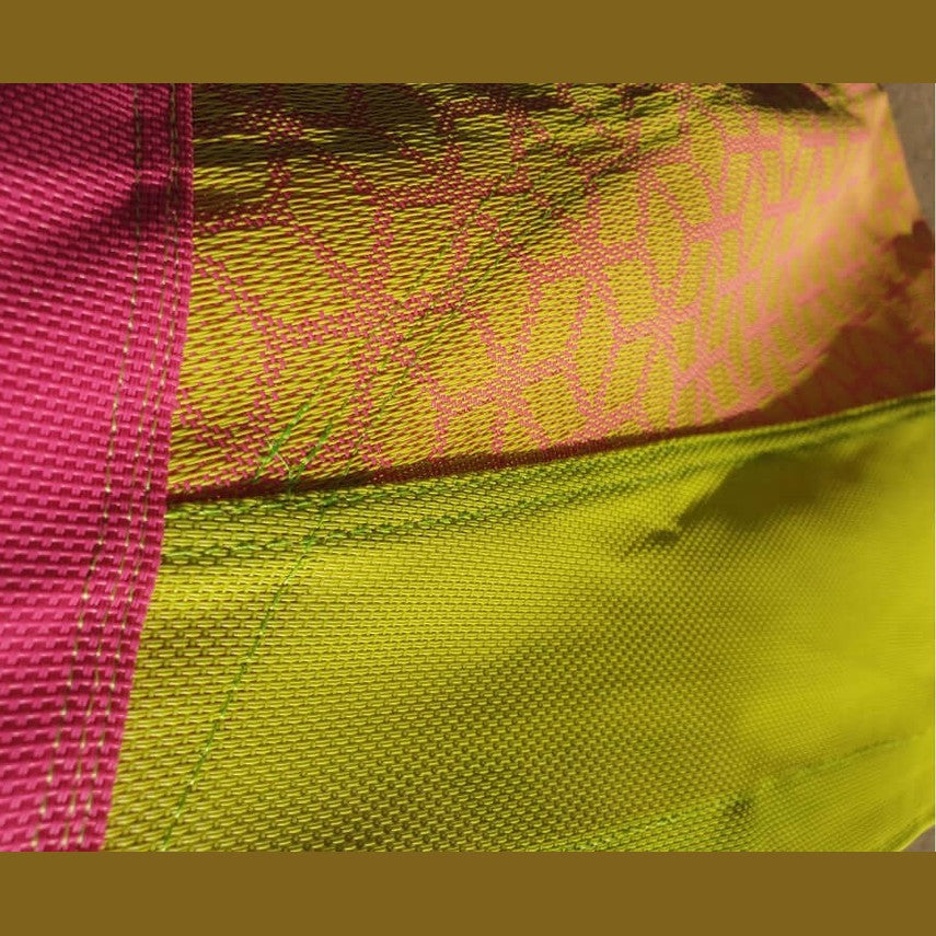 close up of the material and pattern of the pink and yellow kBT denoh cacoon swing