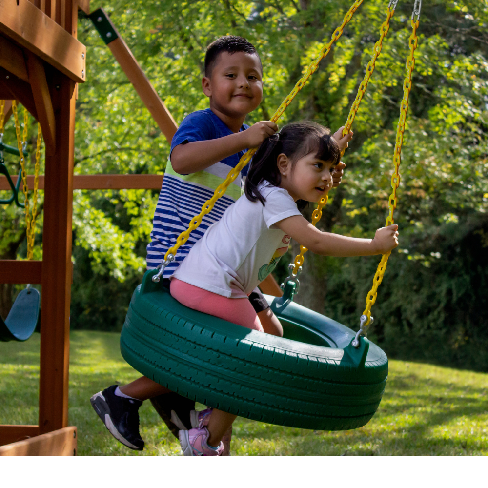 Two children on a tire swing on seagull playground