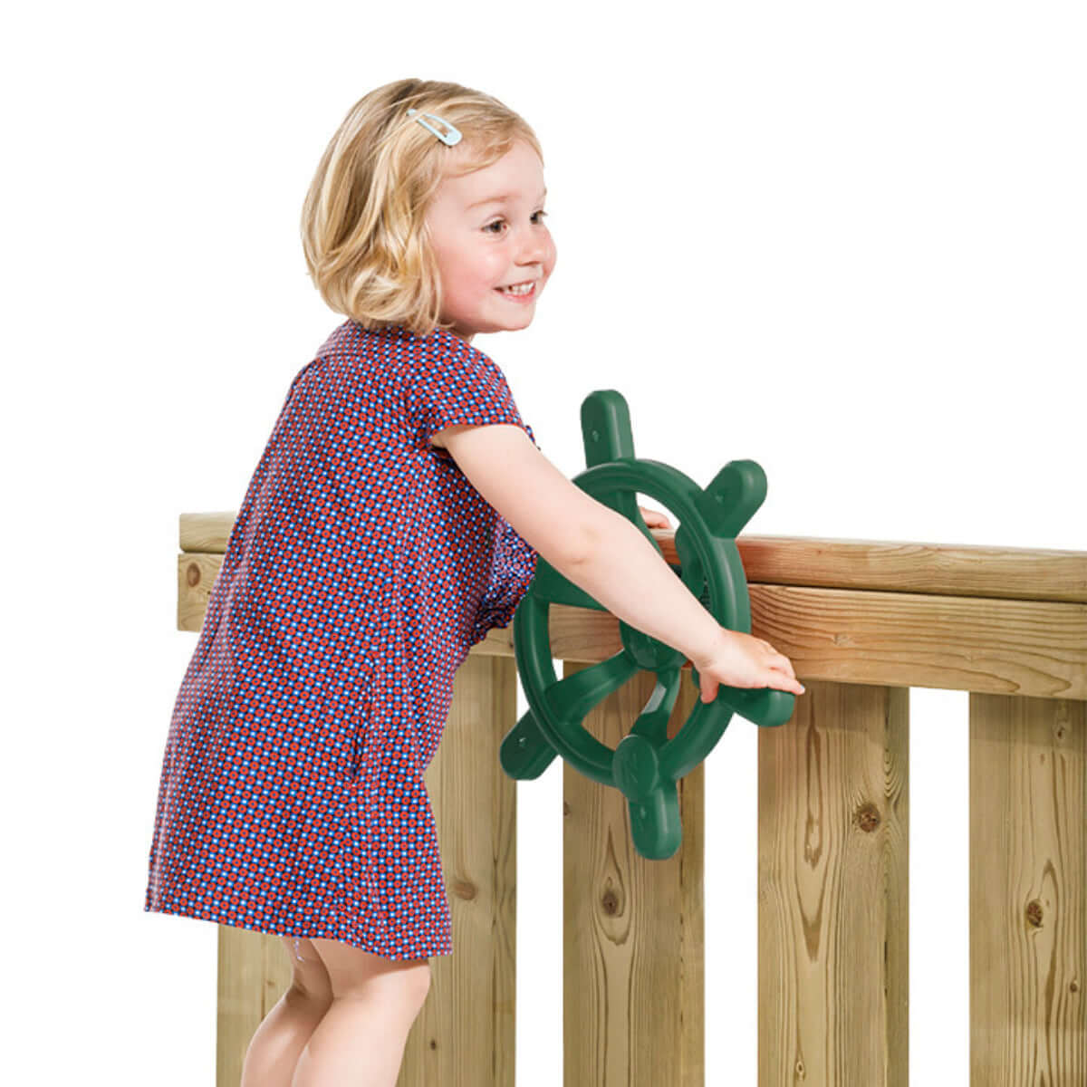 Girl playing with green boat steering wheel at wooden playground