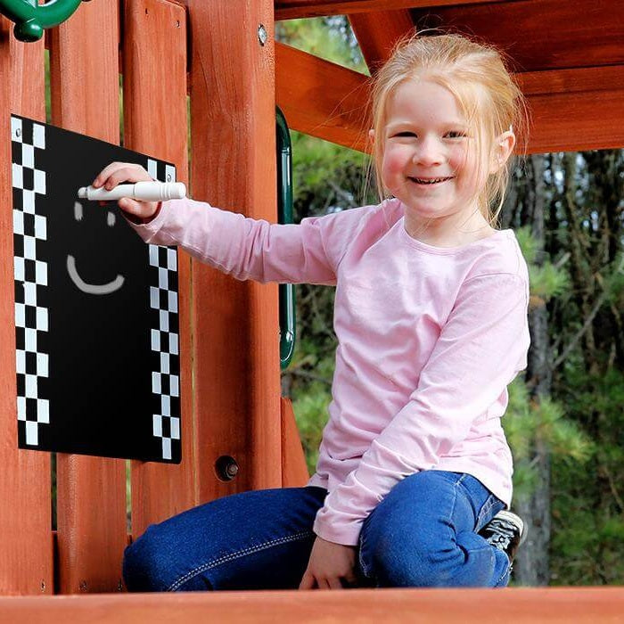 Child holding a blackboard with a smiley face outdoors