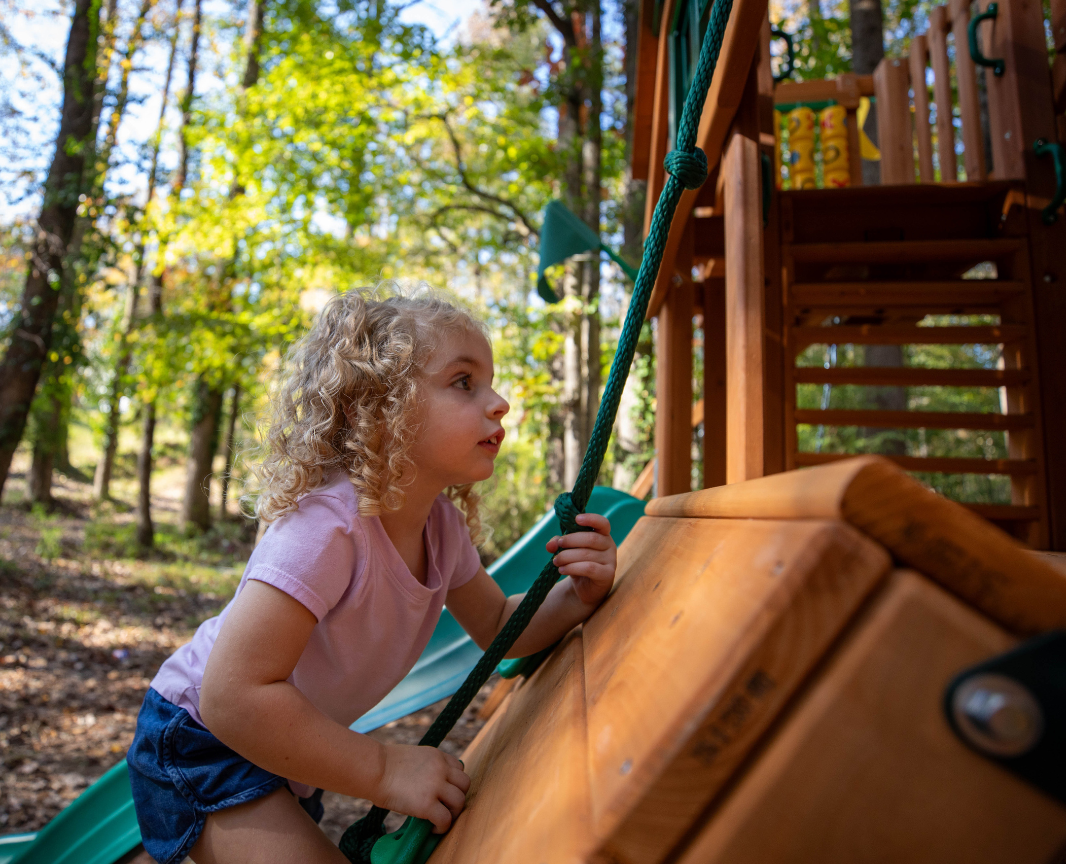 girl climbing up a climbing wall after its safety inspection