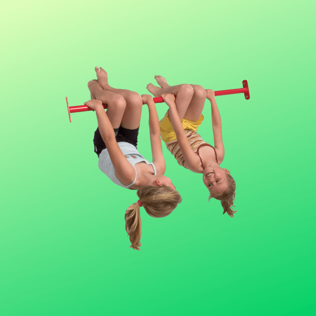 two girls having fun hanging upside down on a red tumble bar.