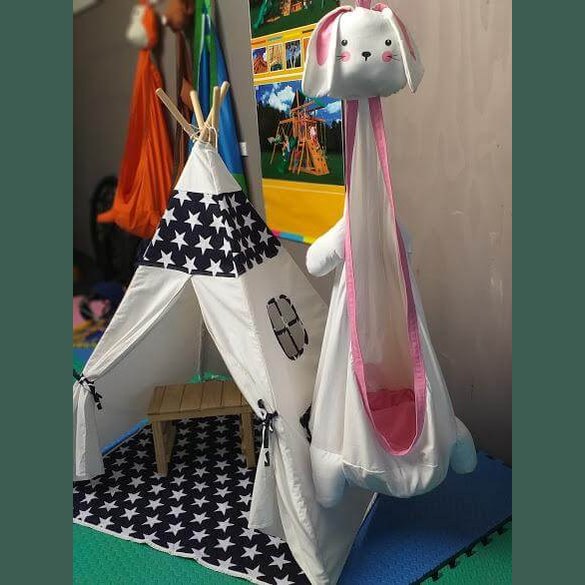 kids play teepee with navy stars next to a cacoon swing
