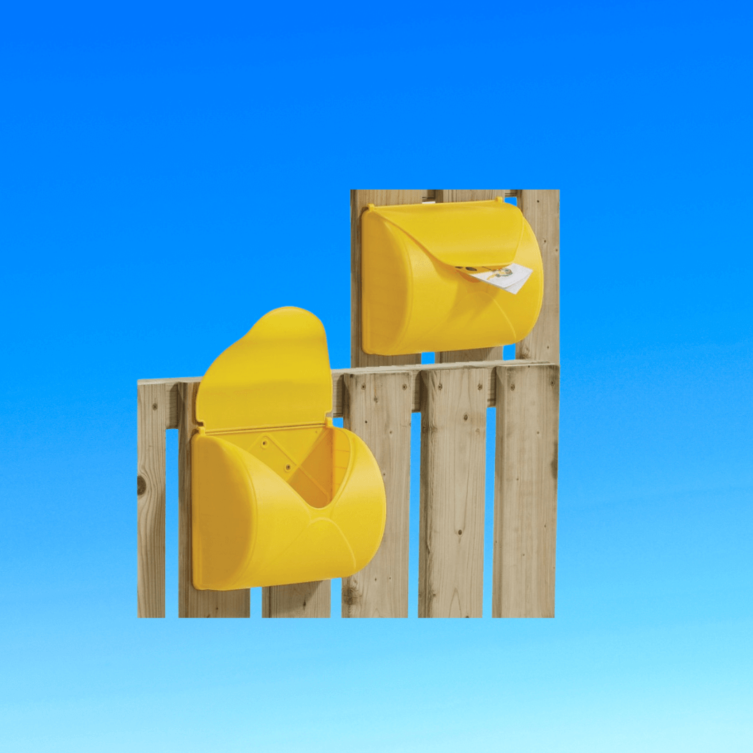 Two yellow  playground mailboxes attached to a wooden fence
