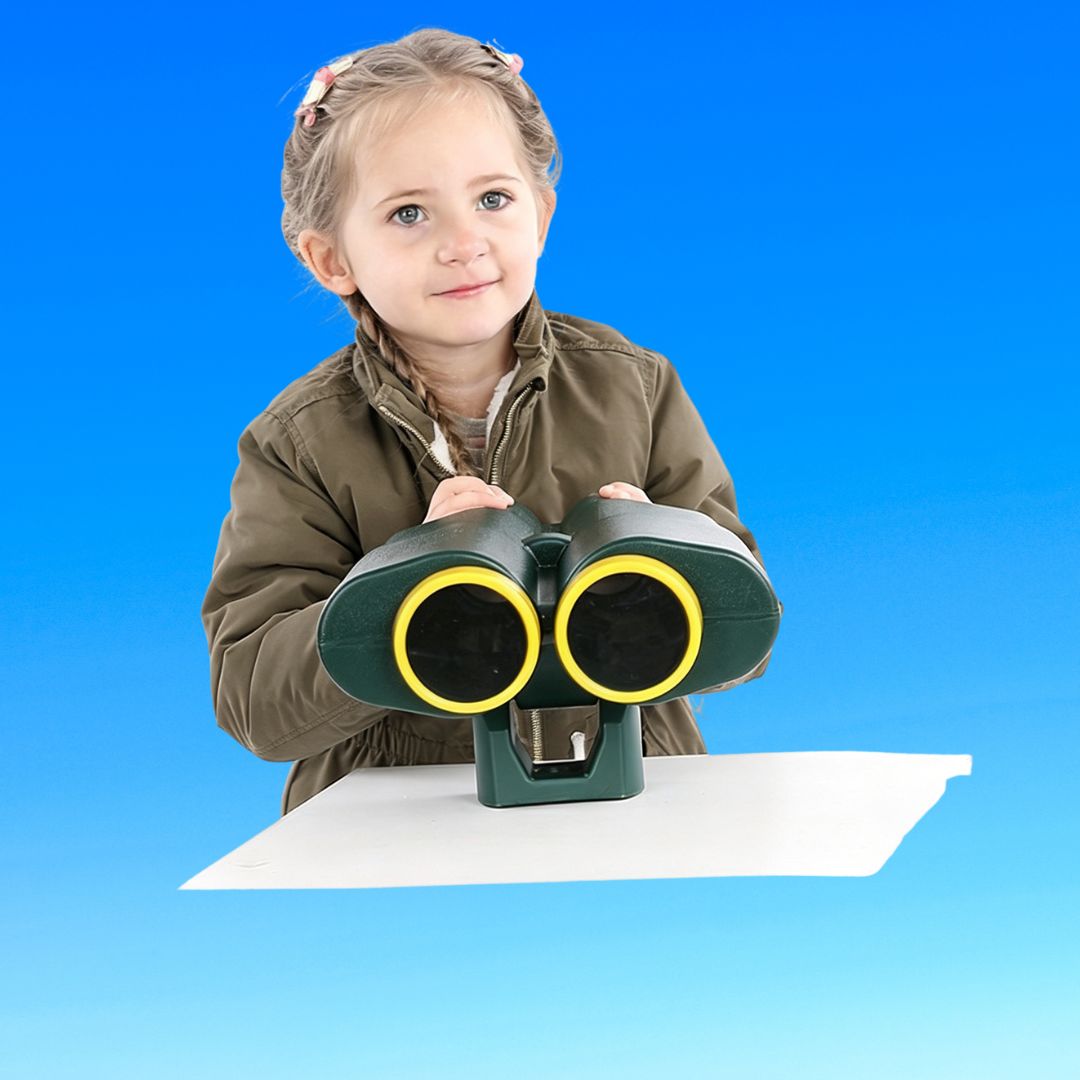 girl playing with green playground binoculars in nz