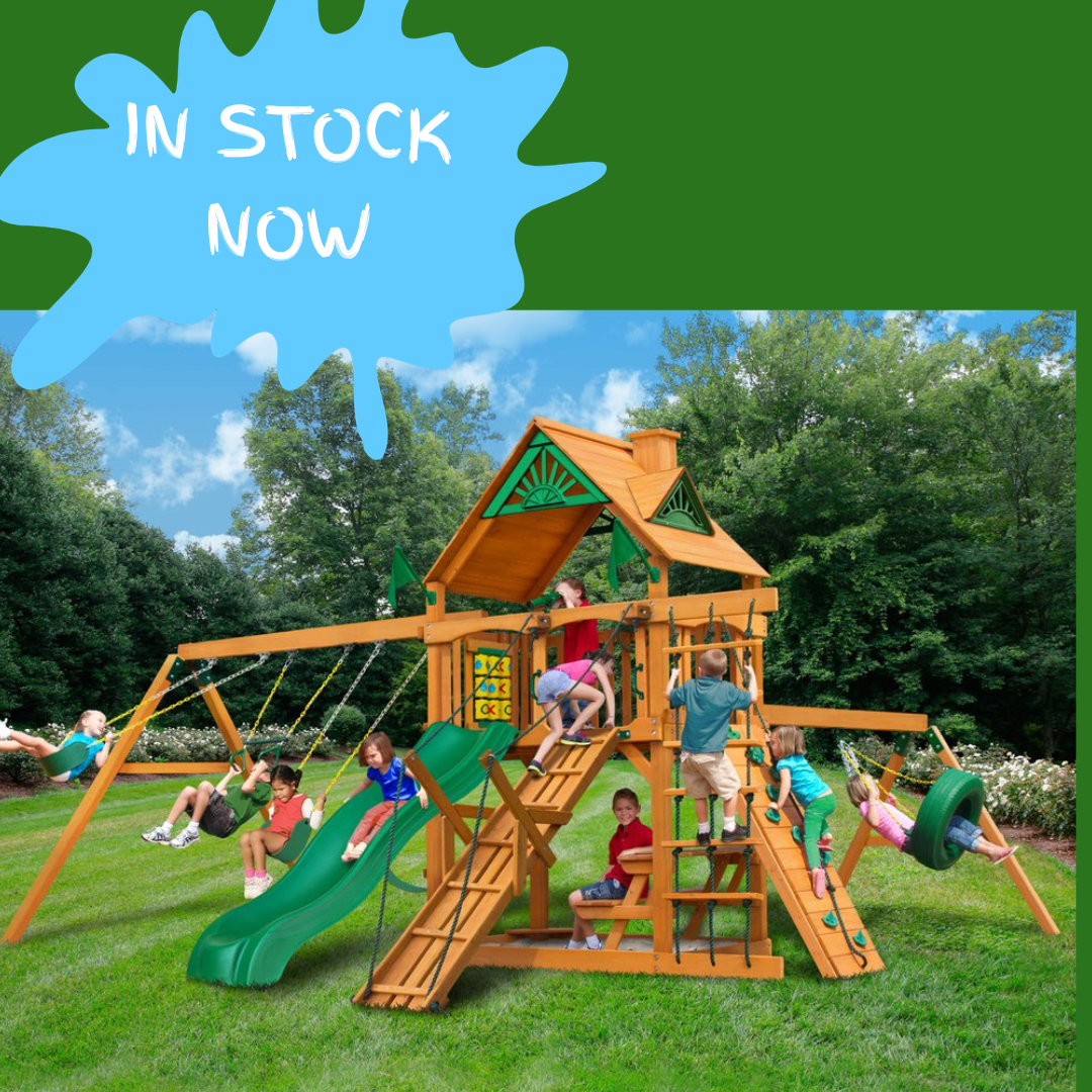 Children playing on a wooden playground set with slides, swings, tyre swing and more