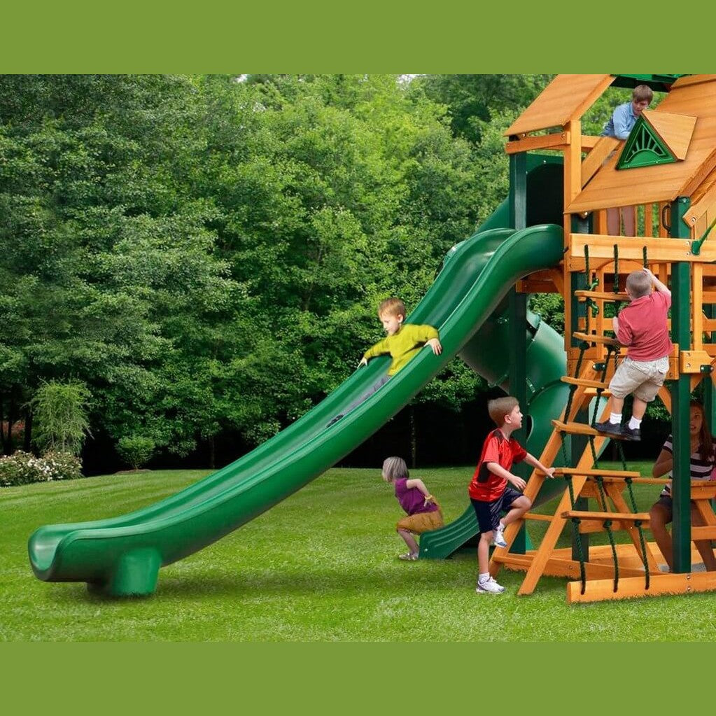 Children on playground and sliding down green slide