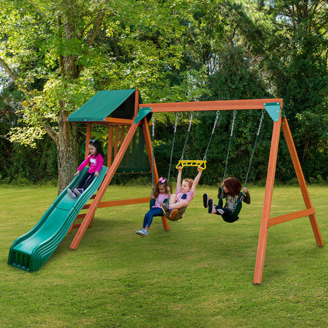 Children playing on a swing set with a green slide in nz backyard