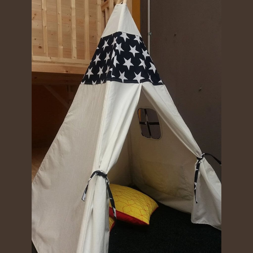 White teepee with star-patterned top in a room setting